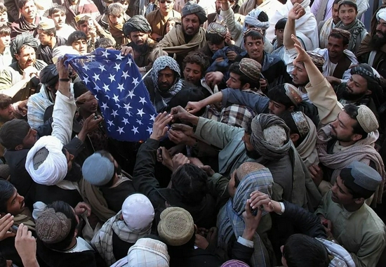 ▲2012年2月，美军焚烧《古兰经》事件发生后，阿富汗示威群众在阿富汗赫尔曼德省街头撕毁并焚烧美国国旗，还有两名美军士兵被愤怒的阿富汗人开枪打死。