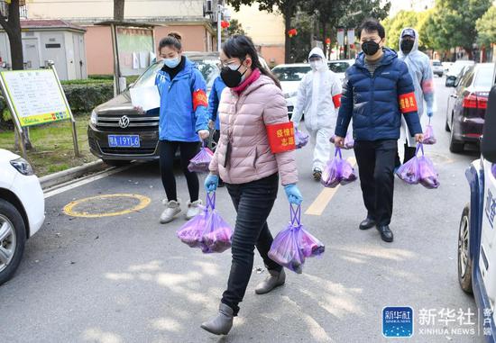 ↑武汉市武昌区华锦社区的志愿者在为社区居民送菜上门（2月23日摄）。新华社记者 程敏 摄