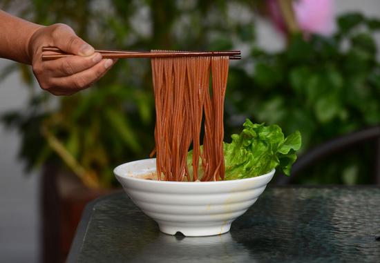 在柳州市一家螺蛳粉店，工人在展示新上市的红高粱螺蛳粉（2月2日摄）。新华社记者 黄孝邦 摄
