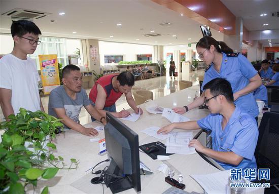 在浙江省宁波市奉化区行政服务中心,市场监管窗口在办理个体户开餐馆“一窗受理、证照连办”业务(2017年8月17日摄)。2017年以来,奉化区积极推进“最多跑一次”改革,加快推进审批信息网络集成,努力让数据多跑路、群众少跑腿,全力打造“指尖上的行政服务中心”。 新华社记者 翁忻旸 摄