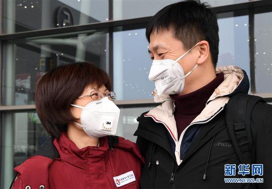  1月26日，在天津滨海国际机场，天津医疗队队员、天津医科大学总医院呼吸科大夫李硕（左）与前来送行的丈夫道别。当日，来自天津32所医院的138名医护人员，从天津滨海国际机场启程，驰援武汉。新华社记者马平摄