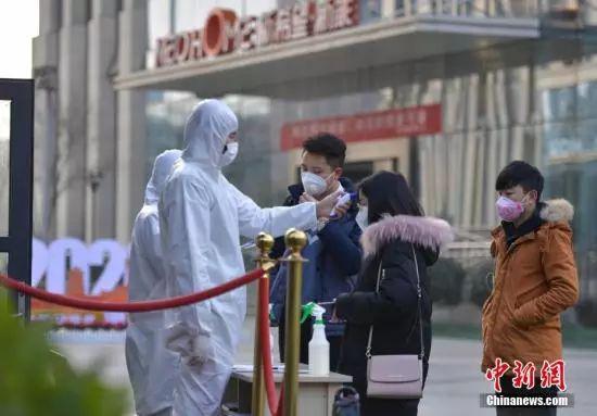  2月11日，成都市锦江区锦江创业园区一复工企业门口，上班族消毒、登记、测体温后进入单位。中新社记者 刘忠俊 摄