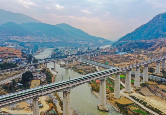  2022年12月24日，一列复兴号动车组在四川省冕宁县境内的新成昆铁路进行开通运营前的试跑，远处是老成昆铁路（无人机照片）。新华社记者 王曦 摄