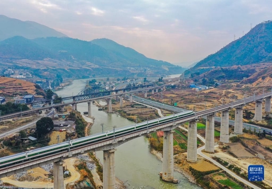 2022年12月24日，一列复兴号动车组在四川省冕宁县境内的新成昆铁路进行开通运营前的试跑，远处是老成昆铁路（无人机照片）。新华社记者 王曦 摄