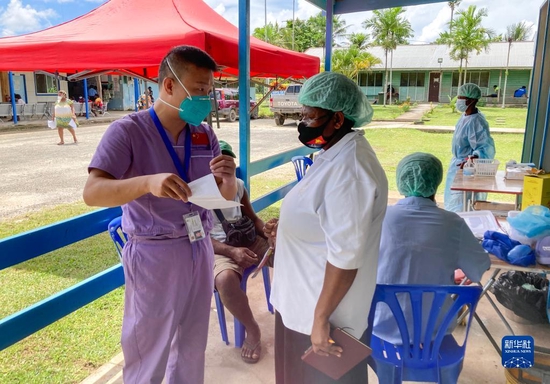 2021年8月25日，在巴布亚新几内亚新爱尔兰省卡维恩总医院，中国援巴新医疗队队员向当地医护人员介绍疫苗接种注意事项。新华社发（中国援巴新医疗队供图）