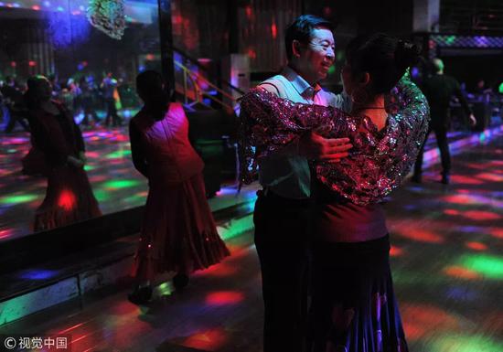 2016年3月，江西南昌市五纬路一家舞厅里，相识的舞伴正在一起跳舞。图片来自视觉中国