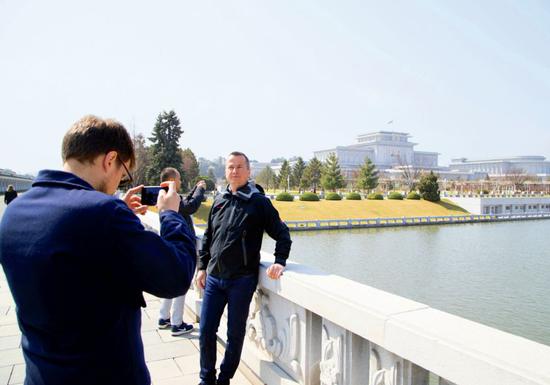 4月11日，在朝鲜平壤锦绣山太阳宫前，外国访客在拍照。摄影/汪许凯