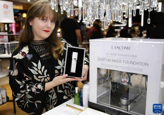 2019年10月25日，在法国巴黎，一名顾客展示欧莱雅集团的美妆黑科技产品：兰蔻定制粉底液。该产品曾连续在进博会上展出。　新华社记者 高静 摄