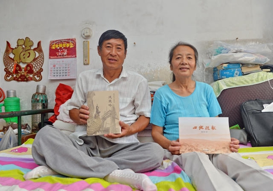 △杨玉芳（左）、高志宏（右）夫妇在家中展示他们所写的书。