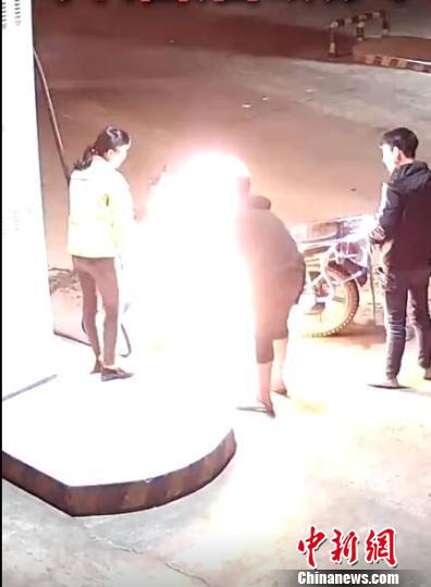 图为视频监控截图显示醉酒男子在加油站点燃摩托车油箱。云南警方供图