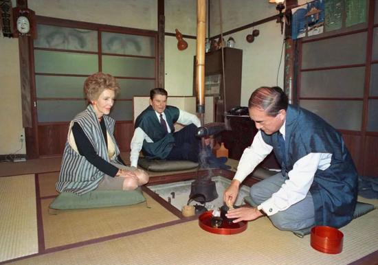 此照片摄于1983年11月11日，日本首相中曾根康弘（右）与美国总统里根和妻子南希在东京西部日诺的首相休闲屋度过时光。中曾根康弘被认为是日本最“国际化”的政治领导人，曾因与美国总统里根的友谊而闻名。