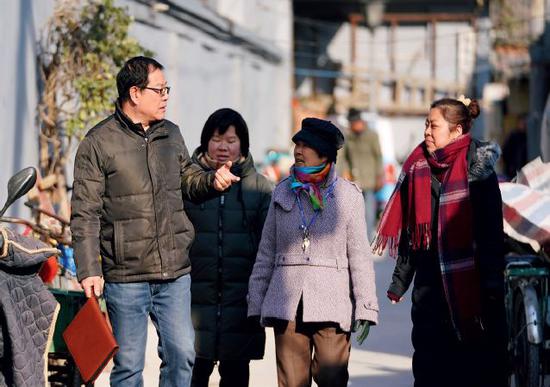 　2017年12月13日，刘跃明（左一）与街巷居民蔡阿姨（右二）和社区工作人员一起在街巷内巡视了解情况。刘跃明是北京市东城区人民市场东巷街巷长，责任街巷总长204米。图/新华