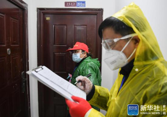  ↑武汉市青山区工人村街道青和居社区网格员李文丽（左）在上门排查（2月18日摄）。新华社记者 程敏 摄