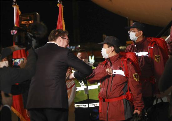 3月21日，在塞尔维亚首都贝尔格莱德，前来迎接的塞尔维亚总统武契奇（左）与中国援助塞尔维亚抗疫医疗专家组成员“碰肘”致意。由中国国家卫生健康委员会组建、广东省卫健委选派的6名中国专家当天抵达贝尔格莱德，一批由中国政府捐赠的医疗物资也同机抵达。新华社记者石中玉摄