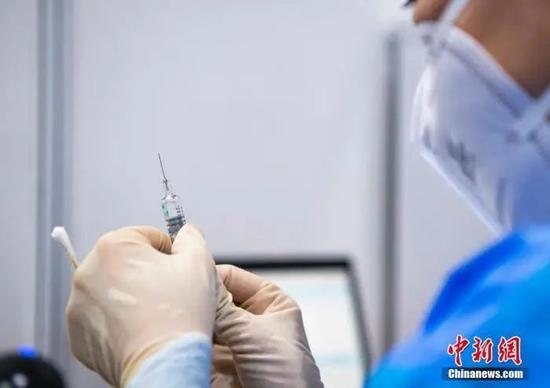 资料图:医护人员在设置于北京市朝阳区朝阳规划艺术馆的临时接种点准备疫苗。中新社记者 侯宇 摄