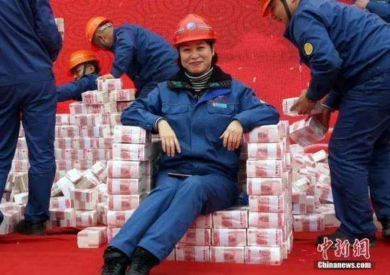 奇葩年终奖:媒体盘点“奇葩”年终奖:袜子鸡蛋和避孕套 一位员工坐在以现金堆成的“座椅”上。 来源 / 中新网 (王昊阳 摄)