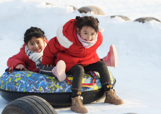 2021年1月1日，在甘肃省临夏回族自治州临夏市金色草滩景区，小朋友在滑雪圈。新华社发（史有东 摄）