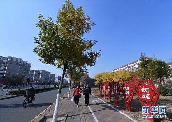 在天津市南开区，路人在蓝天下出行（2018年11月1日摄）。 新华社记者 李然 摄