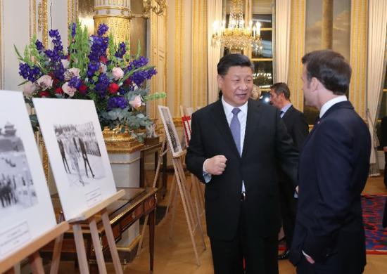 3月25日，国家主席习近平与法国总统马克龙参观中法建交55周年和留法勤工俭学运动100周年图片展。新华社记者 鞠鹏 摄