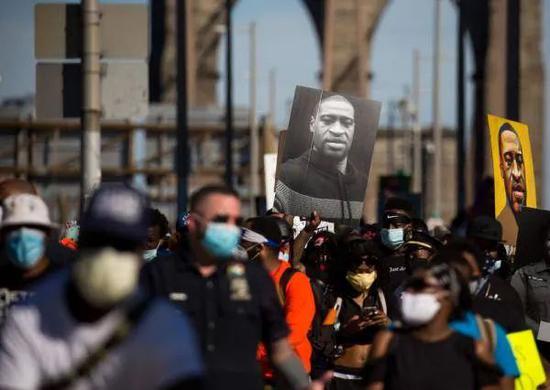 6月13日，抗议者手举弗洛伊德的肖像通过美国纽约布鲁克林大桥。