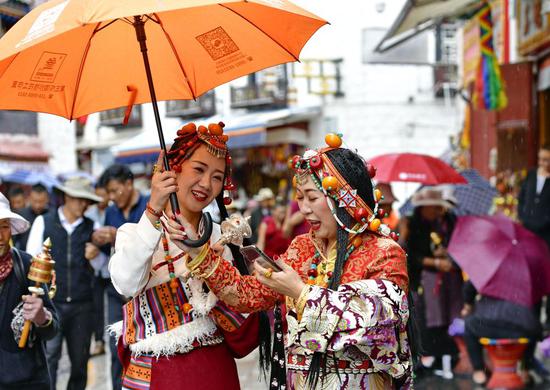 ↑2019年7月3日，游客在拉萨八廓街上游览。