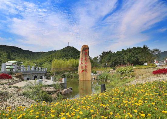 在浙江安吉余村，铭刻着“绿水青山就是金山银山”的石碑就立在村头，无声地向游客“讲述”着余村的蜕变。 夏鹏飞摄