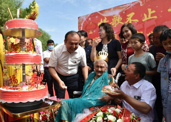 2020年6月25日，阿丽米罕·色依提（中）在新疆疏勒县庆祝134岁生日现场。（记者高晗 摄）