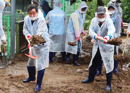 8月11日，韩国国务总理李洛渊等官员慰问灾民，帮忙铲土。人民视觉 图