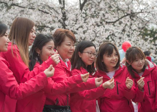 3月13日，上海第四批中医医疗队龙华医院医护人员在武汉大学樱花树下合影。