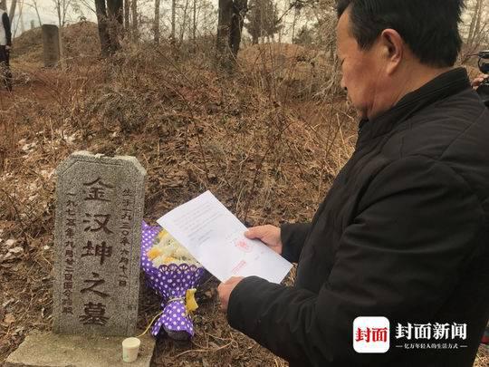 金家大哥在父亲坟前念读弟弟金哲宏的无罪判决书。