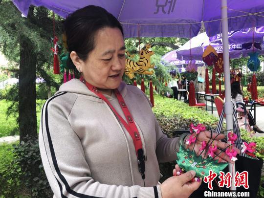 图为兰州手工艺人方亚蓉展示自己亲手绣制的传统香包。　徐雪 摄