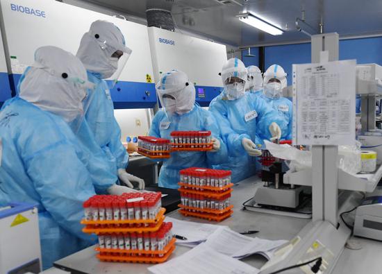 检测人员在北京一医学检验实验室做处理样本前的准备工作（6月25日摄）。新华社记者 张晨霖 摄
