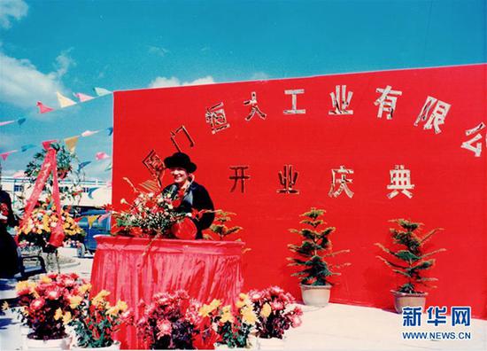 上世纪90年代初，黄紫玉在厦门的公司成立时站在红色背景板前讲话（受访者供图）。 新华社发