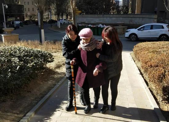 1月25日中午，获假释的李淑贤在两个女儿的搀扶下回家。新京报记者王飞 摄