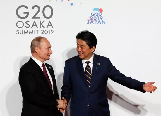  2019年6月28日，日本首相安倍在会场迎接俄罗斯总统普京。