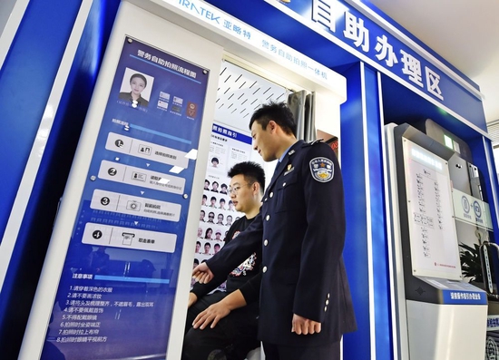 在辽宁省本溪市公安局北地派出所民警指导下，市民通过自助体检机完成机动车驾驶人检测项目（2021年12月10日摄）。新华社发