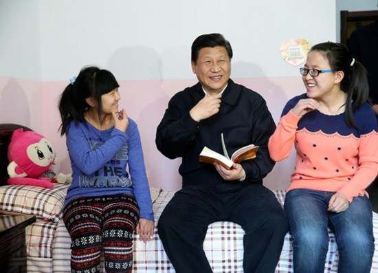 2014年1月28日，习近平在呼和浩特市儿童福利院宿舍鼓励聋哑女孩王雅妮（左）和放假“回家”的大学生闫志净好好学习、学业有成。 新华社记者 兰红光 摄