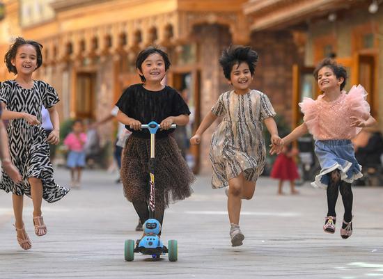 孩子们在新疆和田市鸽子巷奔跑玩耍（2020年5月27日摄）。