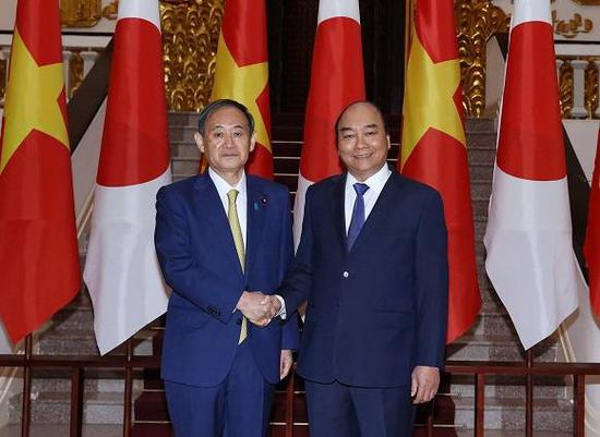 (图片说明:10月19日,在越南首都河内,越南总理阮春福(右)会见到访的日本首相菅义伟。来源:新华社)