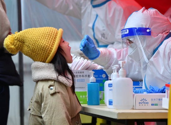 2022年1月10日，在郑州市二七区政通路一处核酸检测点，医务人员为小朋友进行核酸检测取样。新华社发