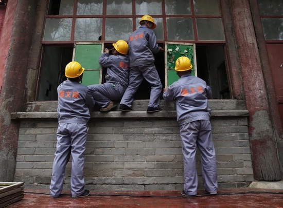 2015年4月2日，大高玄殿建筑群，工人们将需要更换的玻璃窗拆下。