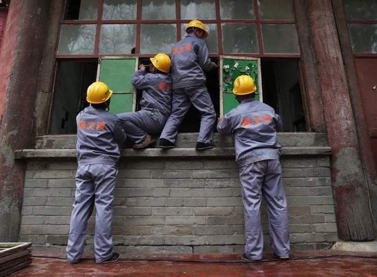 2015年4月2日,大高玄殿建筑群,工人们将需要更换的玻璃窗拆下。