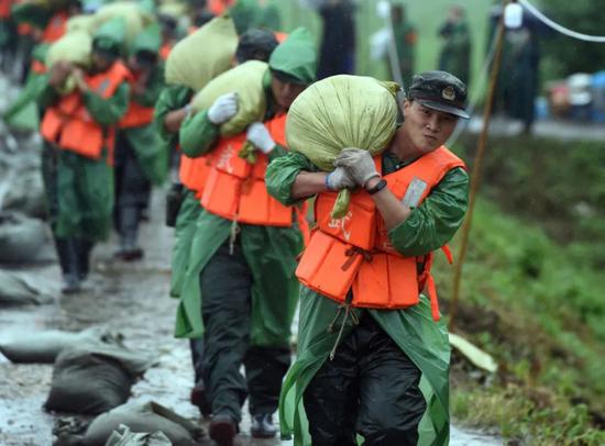 武警安徽总队芜湖支队的官兵在搬运沙袋(新华社记者周牧 摄)