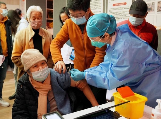 12月9日，在上海市黄浦区打浦桥街道大同居委会，接种小分队的护士在为老年人接种新冠疫苗。新华社记者 刘颖 摄