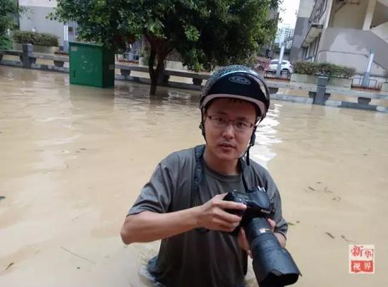  新华社记者宋为伟在台风过后福州齐腰深的水里采访。