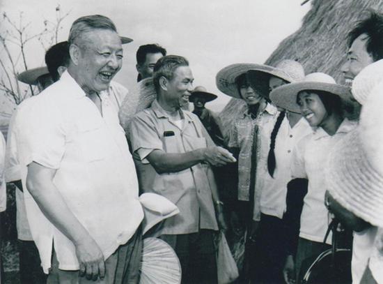  1980年8月底至9月初，习仲勋（左一）在广东湛江农村视察时与青年亲切交谈。