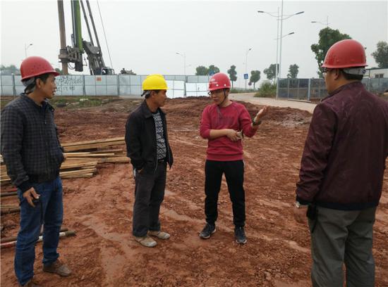 中铁十九局项目经理罗文江（右二）在重庆地铁6号线施工现场交流施工方案（4月19日摄）。新华社发（张振宇 摄）