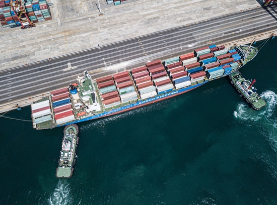  2020年9月23日，引航员指挥两艘拖轮辅助一艘集装箱船靠泊在洋浦港小铲滩码头（无人机照片）。 新华社记者 蒲晓旭 摄