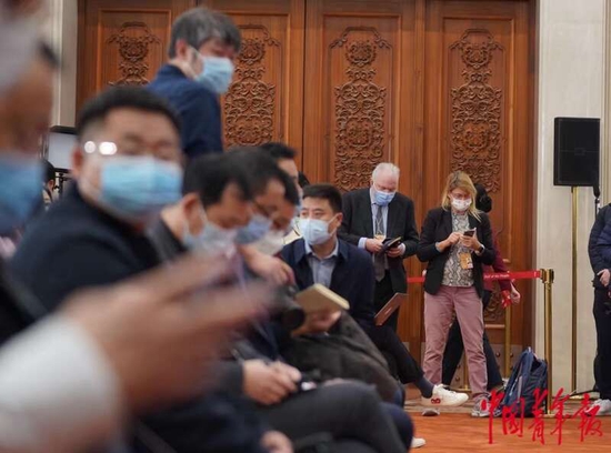  3月3日下午，全国政协十四届一次会议新闻发布会即将开始，中外记者在会场内等待。中青报·中青网记者 李峥苨/摄