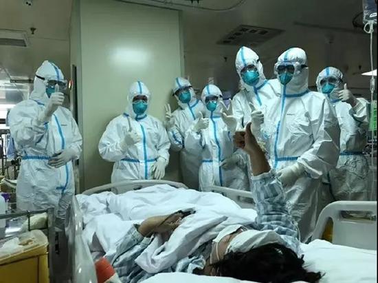 “解放军来了,我们更加坚定必胜信心!”看到军队的医疗队员出现在面前,一名重症患者情不自禁举起大拇指“点赞”。(图片来源:军报记者微信公众号)